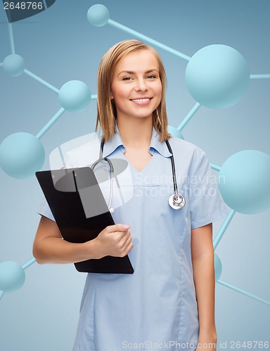 Image of smiling female doctor or nurse with clipboard