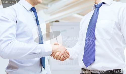 Image of two businessmen shaking hands in office