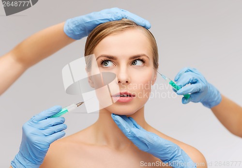 Image of woman face and beautician hands with syringe