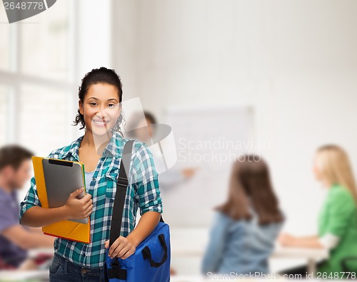 Image of smiling student with folders, tablet pc and bag
