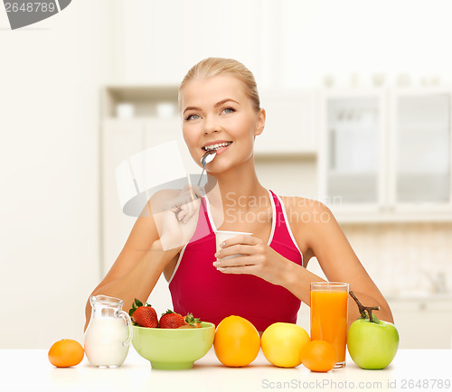 Image of young woman eating healthy breakfast