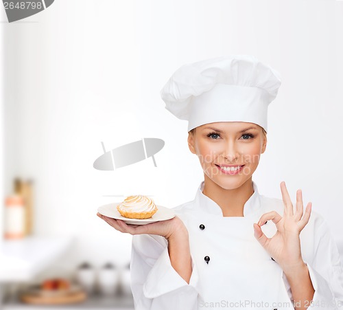 Image of smiling female chef with cake on plate