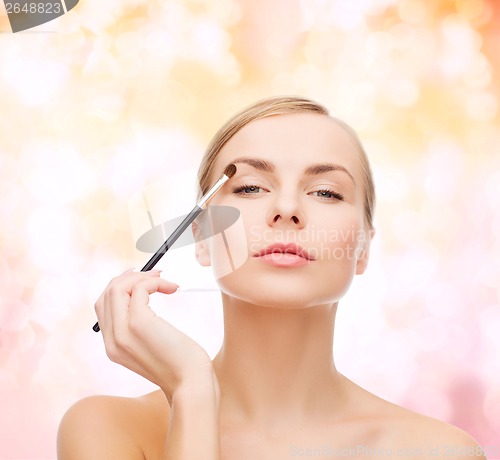 Image of beautiful woman with makeup brush