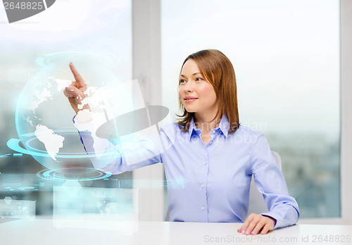 Image of smiling woman pointing to earth hologram