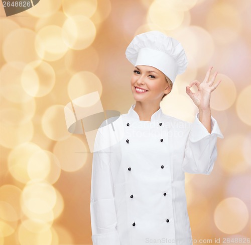 Image of smiling female chef showing ok hand sign