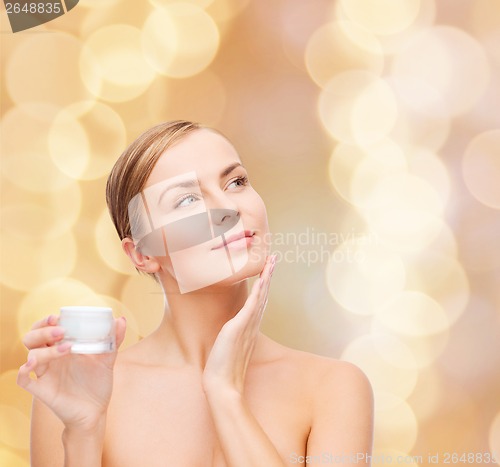 Image of woman applying cream on her skin