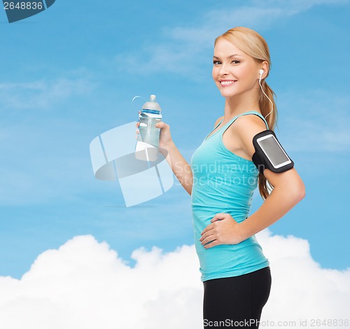 Image of sporty woman running with smartphone and earphones