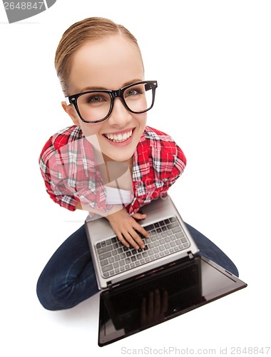 Image of smiling teenage girl in eyeglasses with laptop