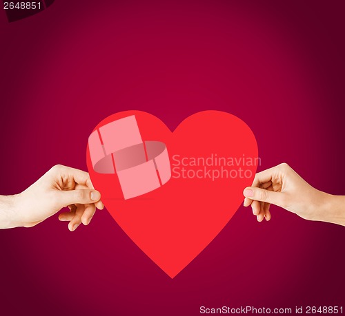 Image of couple hands holding red heart