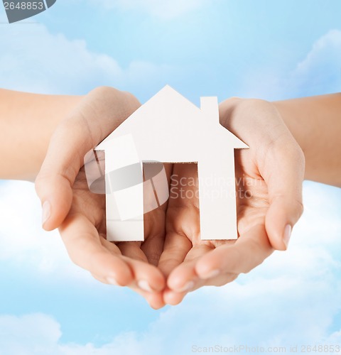 Image of female hands holding paper house