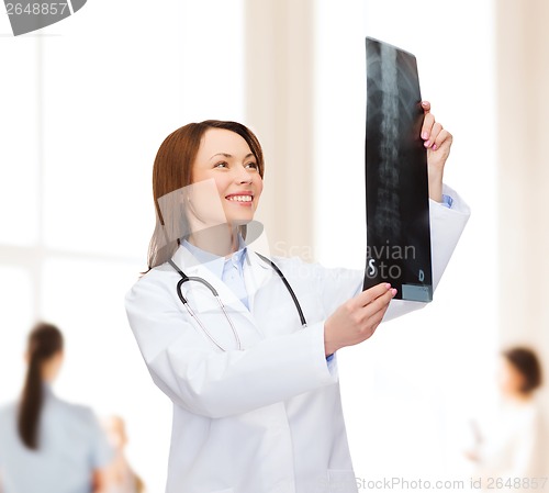 Image of smiling female doctor looking at x-ray