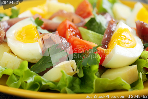 Image of Colorful salad with anchovies, tomatoes and eggs.