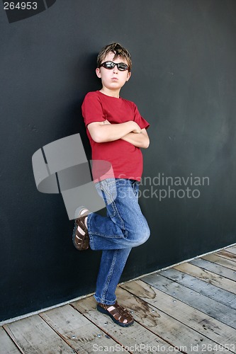 Image of Child leaning against dark wall