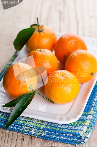 Image of tangerines with leaves in plate