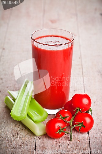 Image of tomato juice in glass, fresh tomatoes and green celery 