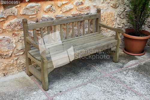 Image of old wooden bench near stone wall