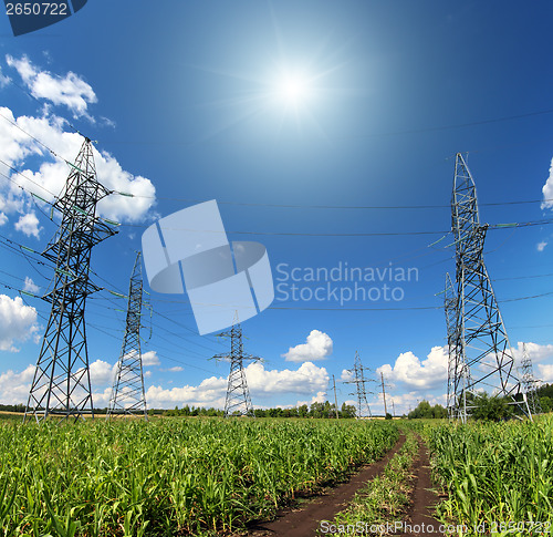 Image of electric masts and road in green field