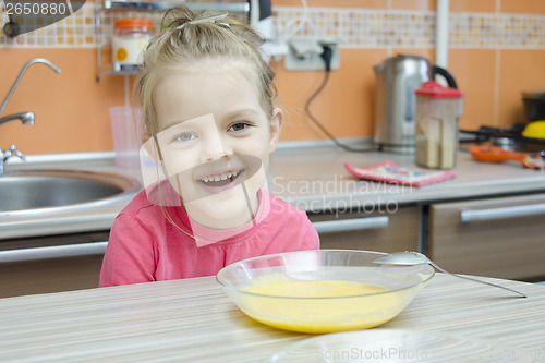 Image of Girl eating porridge in the kitchen