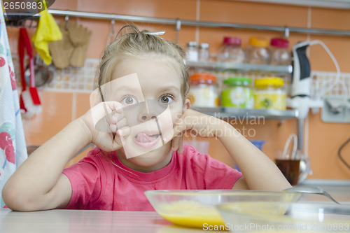 Image of Girl eating porridge in the kitchen
