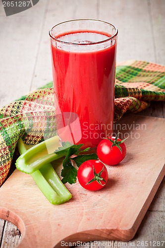 Image of tomato juice in glass, fresh tomatoes and green celery