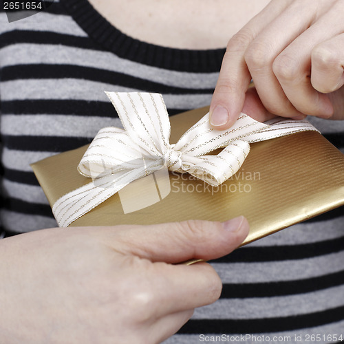 Image of Young woman holding a present