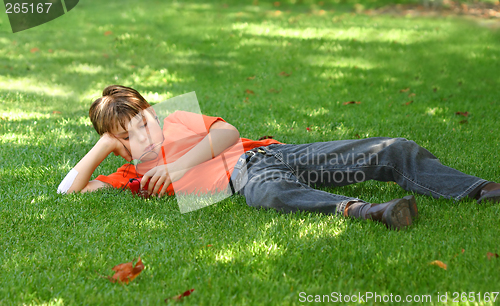 Image of Boy in park listening to mp3 player