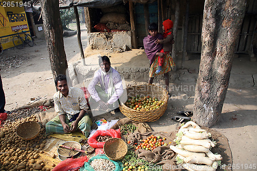 Image of Tribal villagers bargain for vegetables. Kumrokhali, West Bengal, India