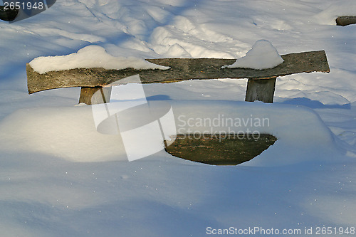 Image of Wooden bench covered with snow