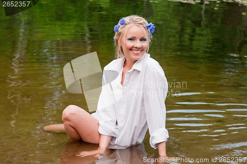 Image of Happy young female sitting in the water