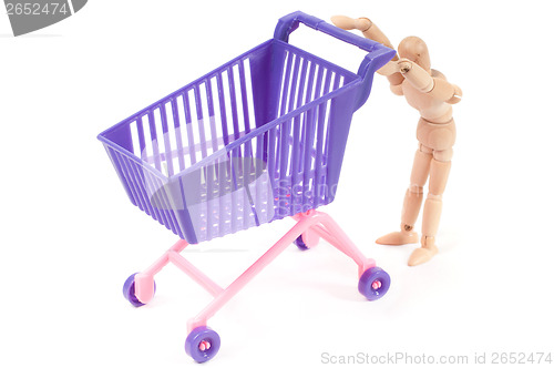 Image of Photo with miniature shopping-cart and wooden man