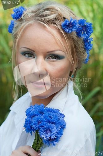 Image of Portrait of beautiful female with blue flowers