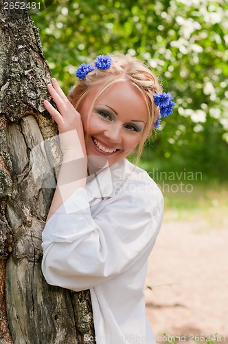 Image of Smiling female in wreath near the tree