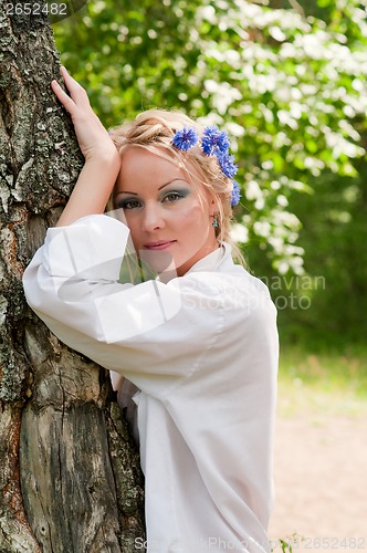 Image of Young female in wreath near the tree