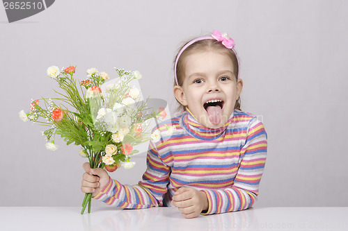 Image of Girl with a bouquet of flowers sitting at table