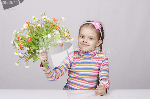 Image of Girl with a bouquet of flowers sitting at table