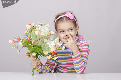 Image of Girl with a bouquet of flowers sitting at table