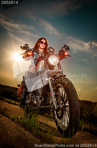 Image of Biker girl sitting on motorcycle