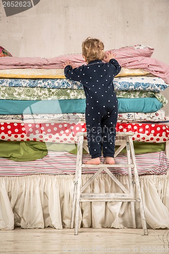 Image of Child climbs on the bed - Princess and the Pea.