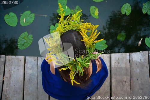 Image of girl by the lake with a wreath on head