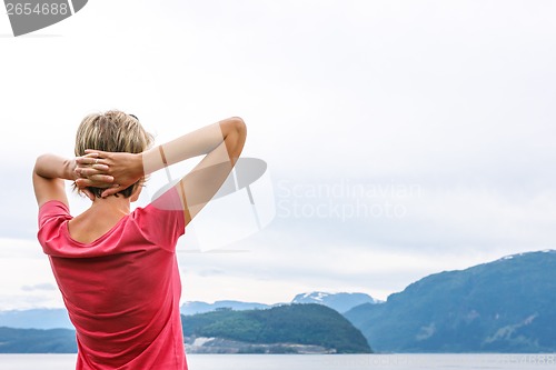 Image of Back view of a woman enjoying a view at fjord