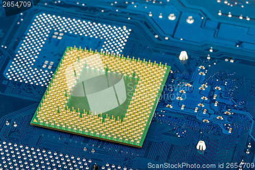 Image of macro of computer processor on blue motherboard