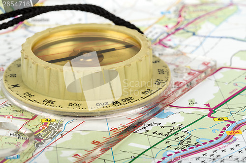 Image of old touristic compass on map 