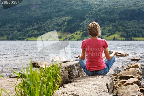 Image of Woman relaxing at lake shore