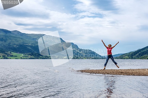 Image of Happy young woman jumping for joy