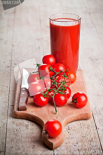 Image of tomato juice in glass and fresh tomatoes 