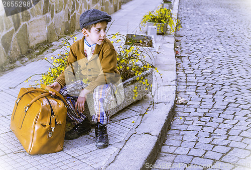 Image of Child on a road with vintage bag