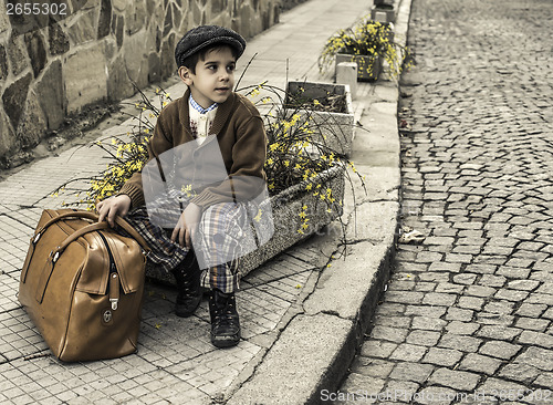 Image of Child on a road with vintage bag