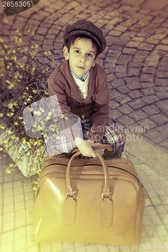 Image of Child on a road with vintage bag