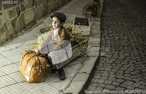 Image of Child on a road with vintage bag