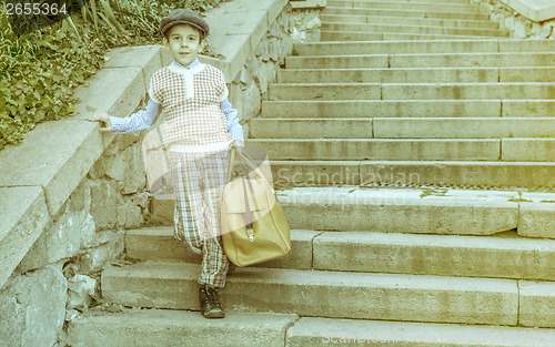 Image of Exterior stairs and child with vintage bag